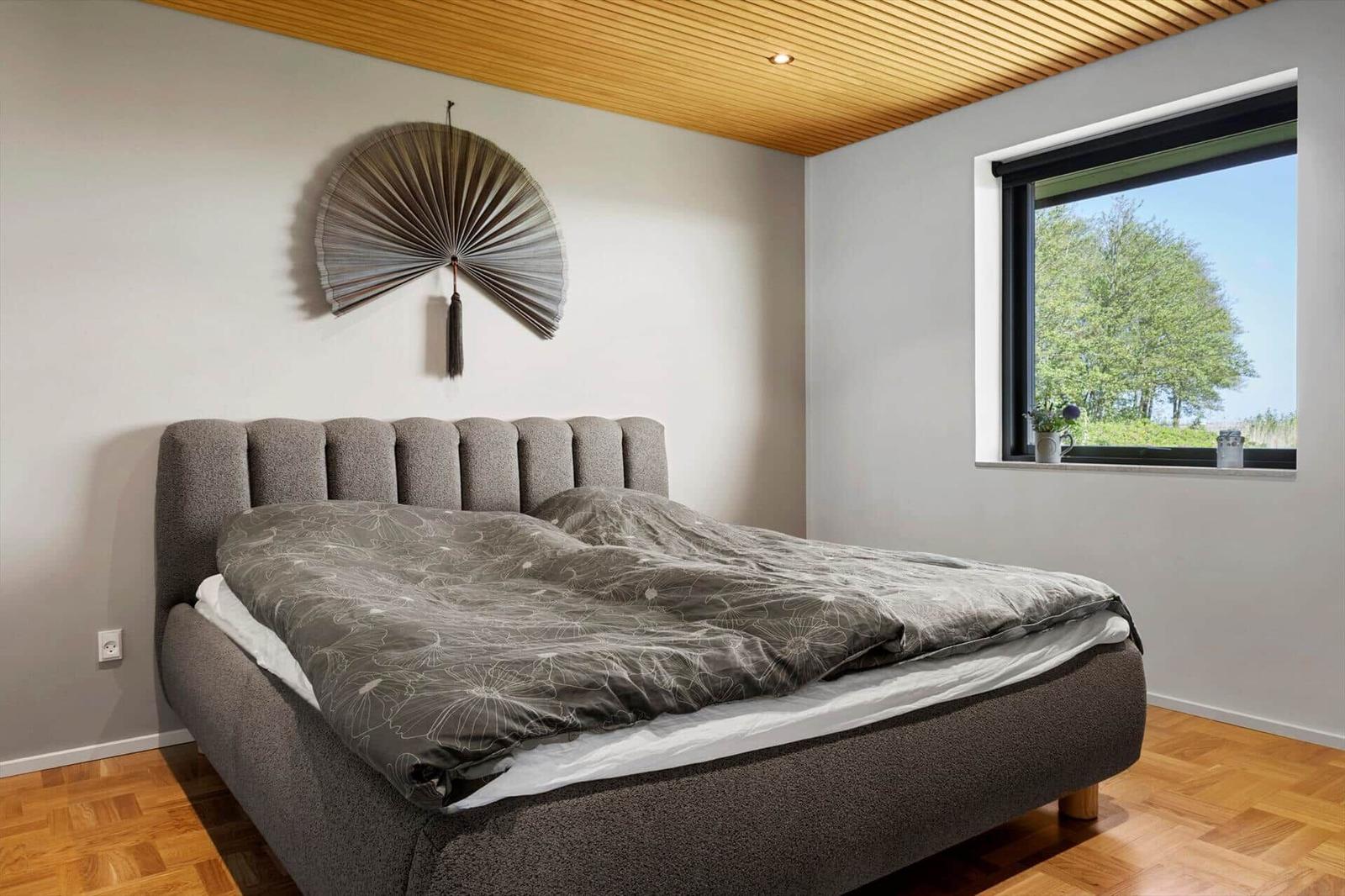 Bedroom with bed, window, and wooden ceiling