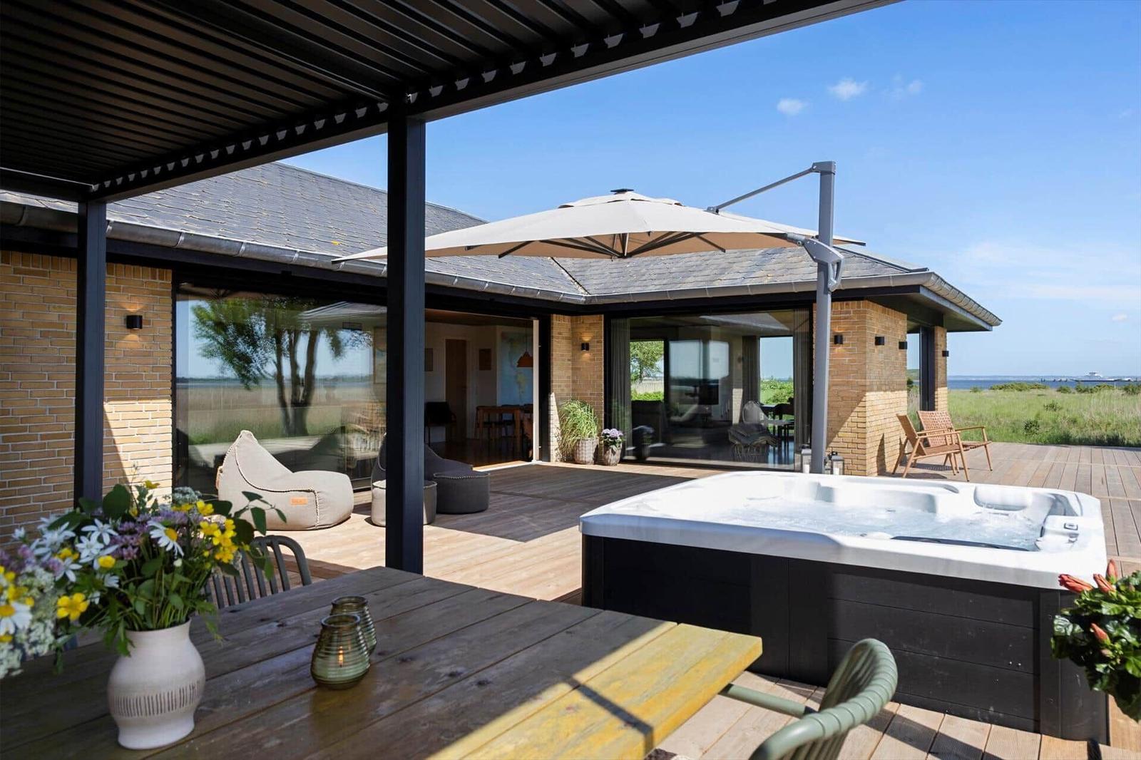 Deck with hot tub, seating, and view of the landscape.