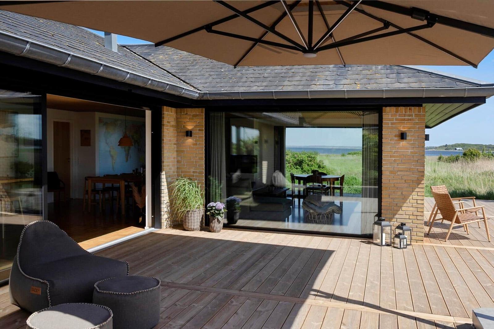 Deck with umbrella, seating, and view of the water.