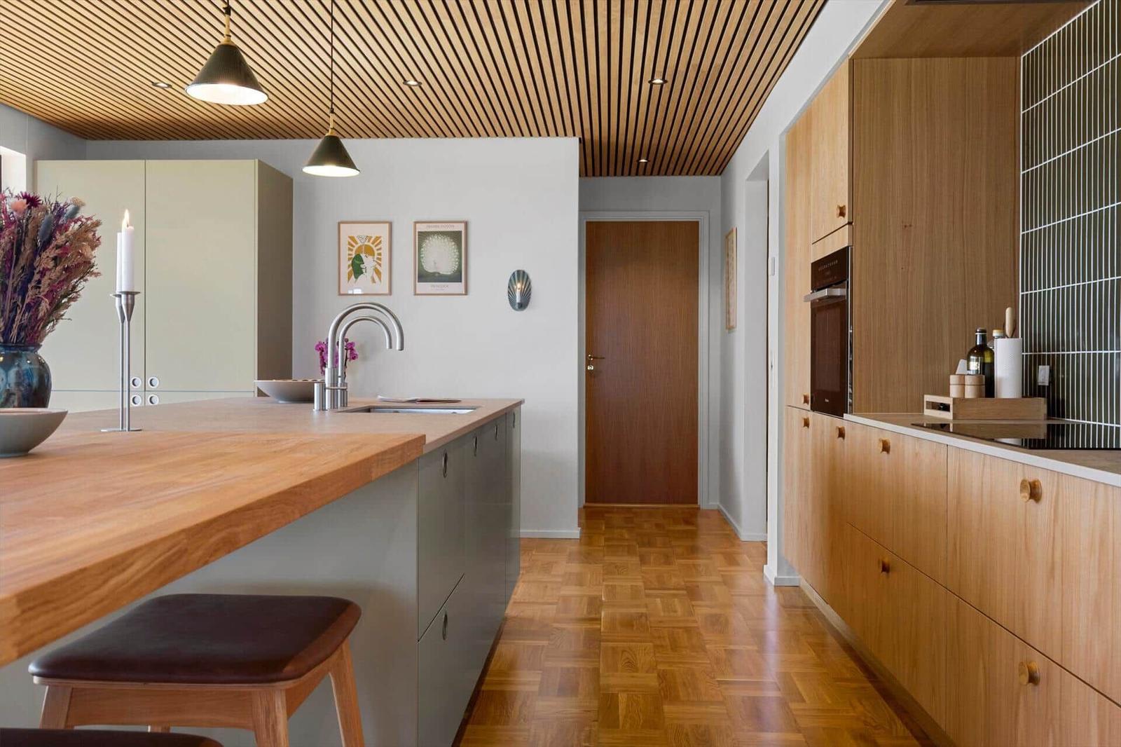 Kitchen with wooden ceiling, worktop, and built-in oven.