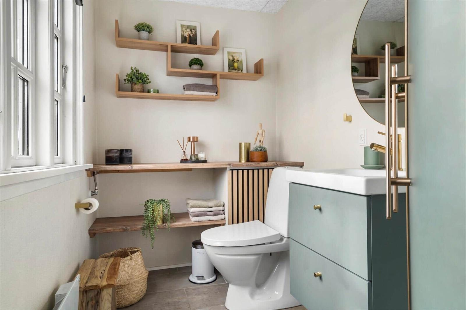 Badezimmer mit Toilette, Waschbecken und Holzregalen an der Wand.