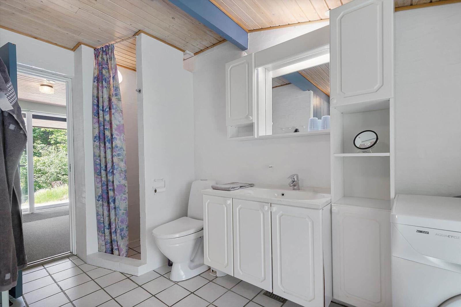 Bathroom with toilet, sink, and shower with curtain.