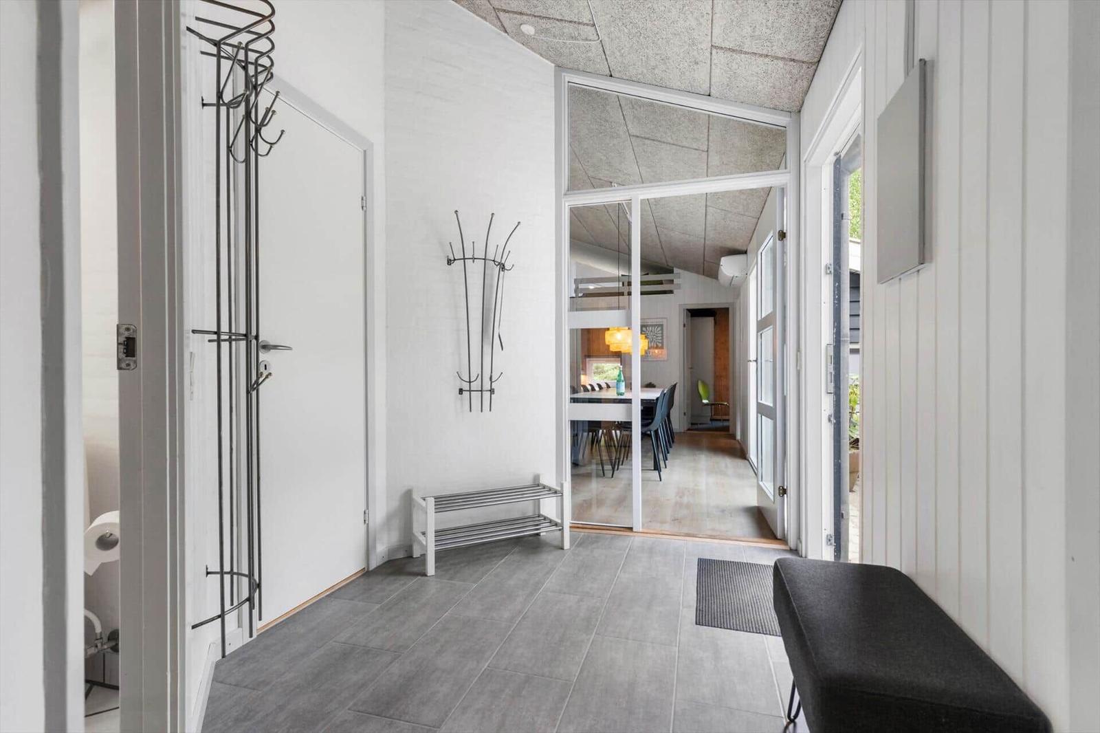 Eingangsbereich mit Garderobe, Bank und Blick in Esszimmer.