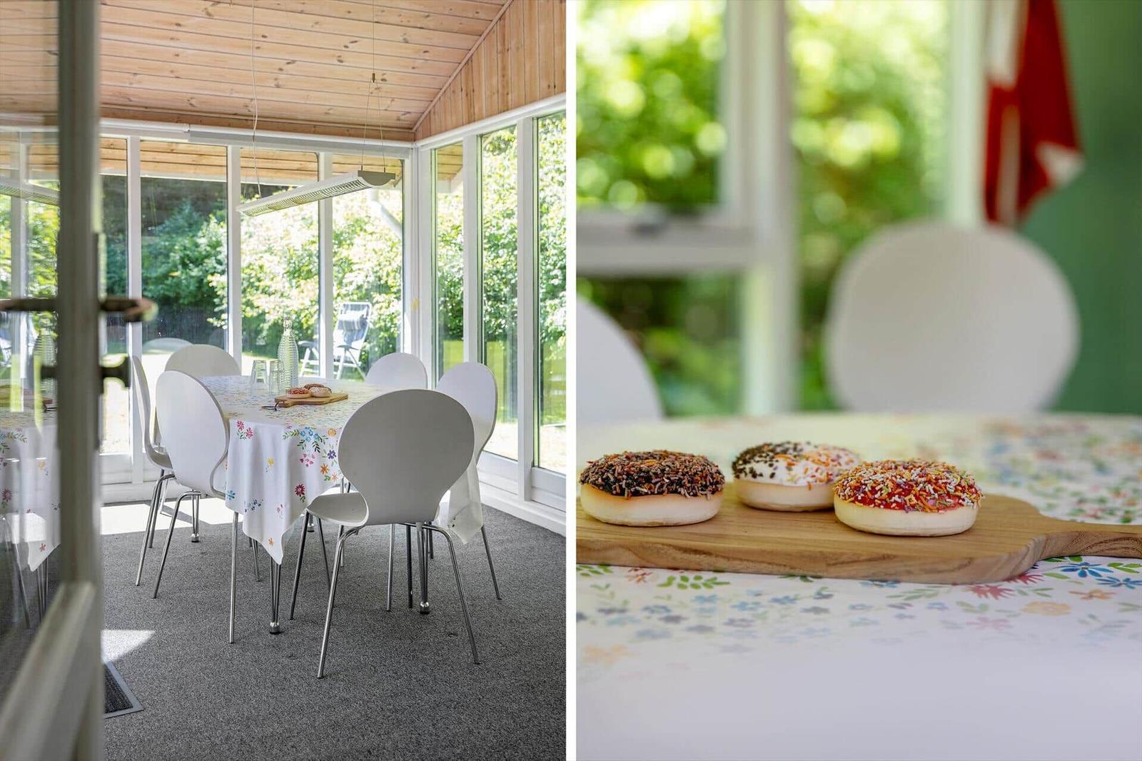 Esszimmer mit Tisch, Stühlen und Blick auf Garten. Donuts auf Holzbrett.