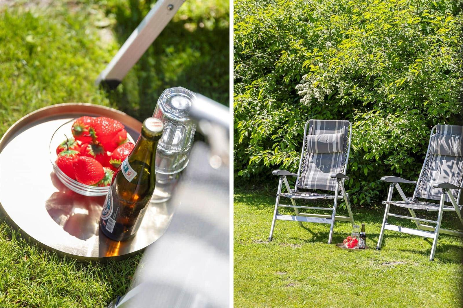 Garten mit Liegestühlen und Obst auf Tisch. Sonniger Platz zum Entspannen.