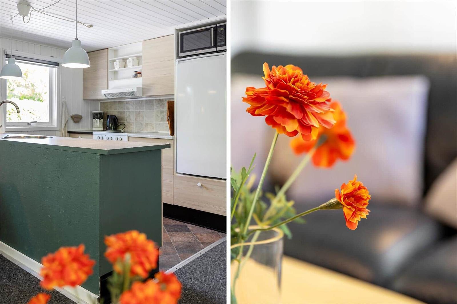 Küche mit Arbeitsplatz und Küchenzeile. Wohnbereich mit Blumen im Vordergrund.