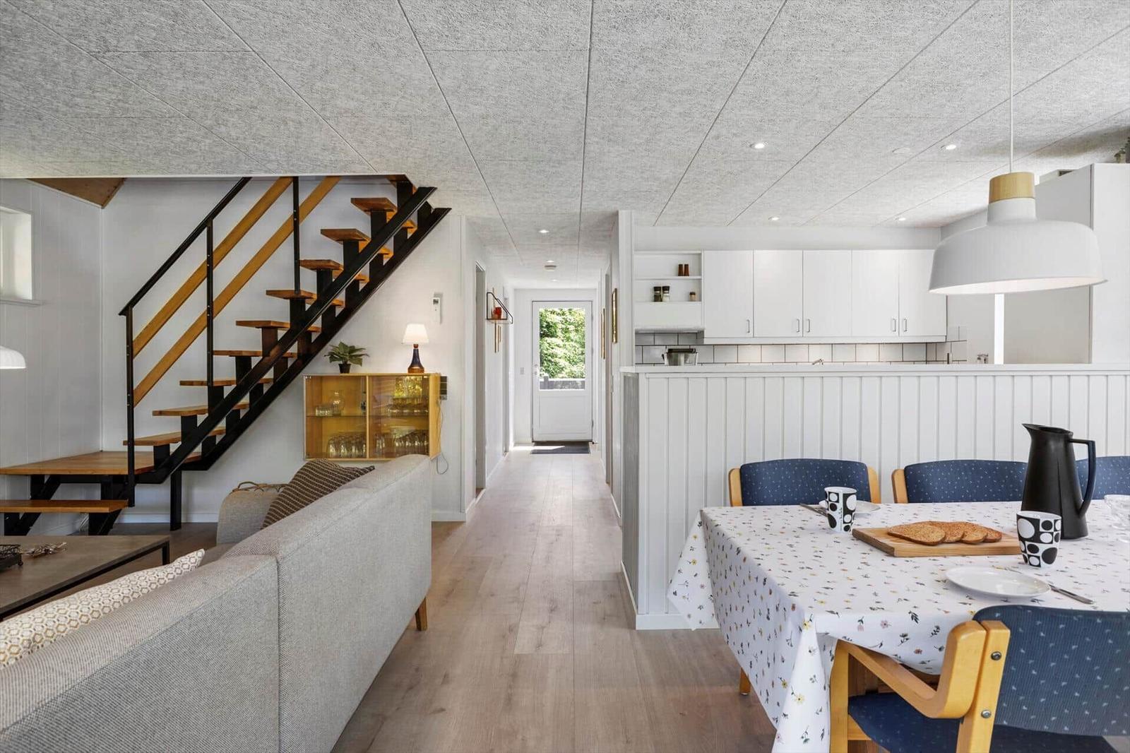 Wohnbereich mit Essbereich, Küche und Treppe zur oberen Etage.