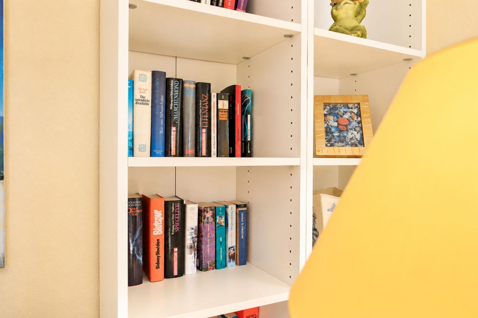 Weißer Bücherregal mit Büchern und Dekoration