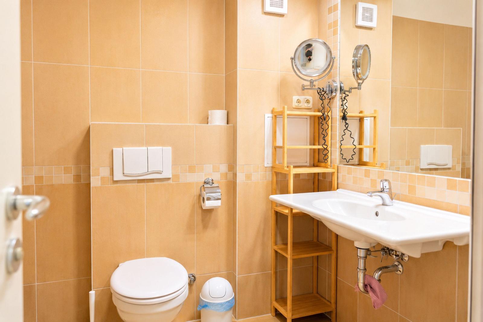 Badezimmer mit Toilette, Waschbecken und Spiegel