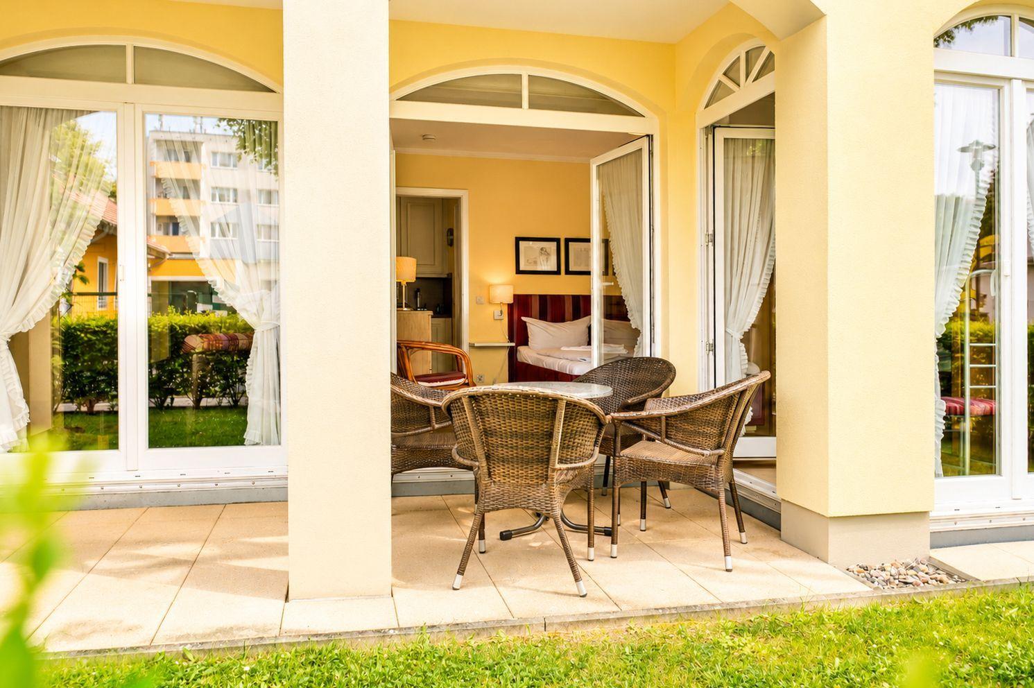 Terrasse mit Sitzgruppe, Blick in Schlafzimmer und Wohnbereich.