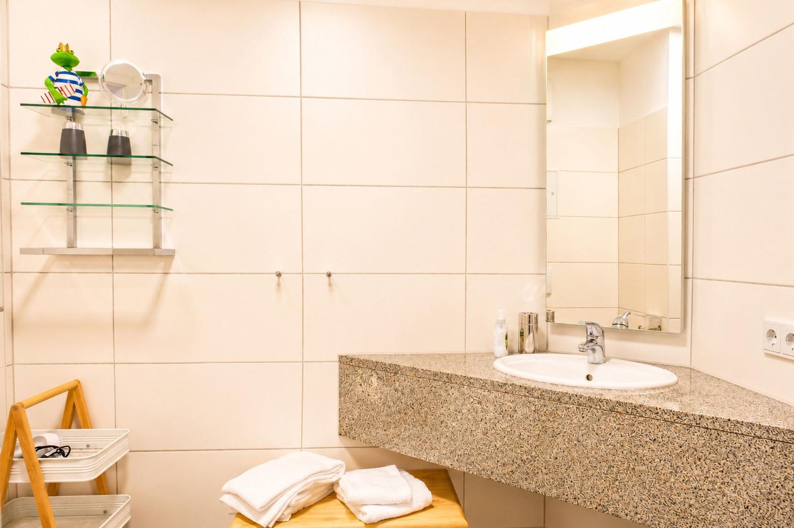 Badezimmer mit Waschtisch, Spiegel und Handtüchern