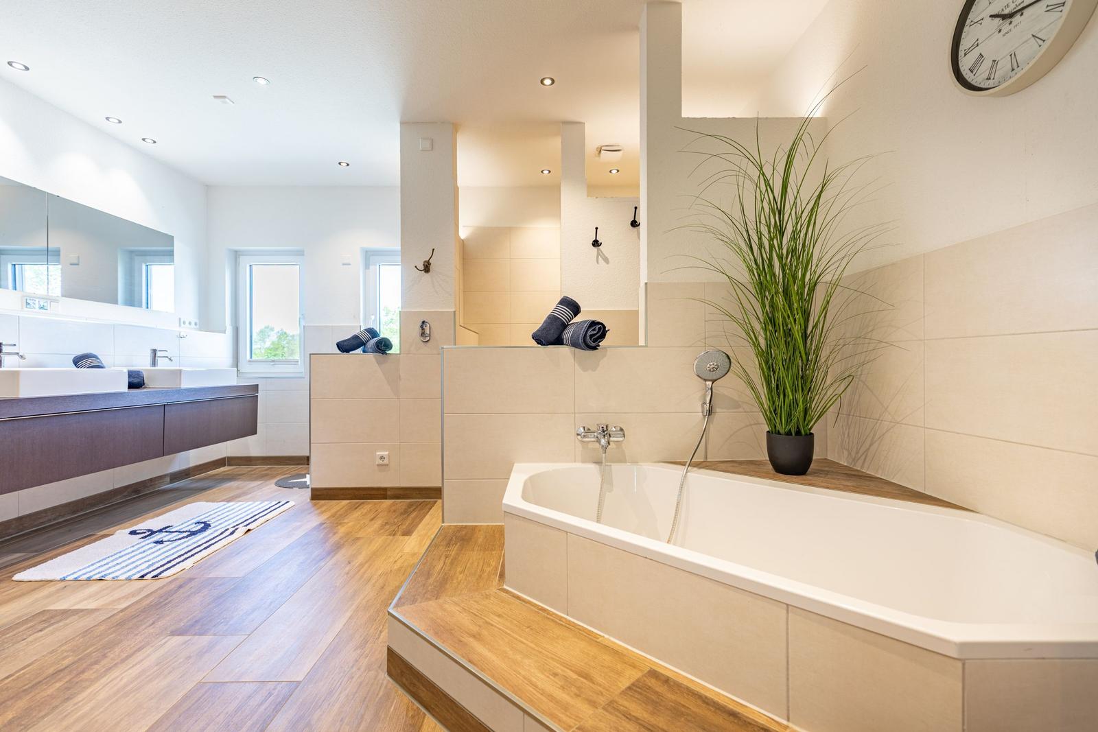 Moderne Badewanne mit Dusche und Waschtisch im Badezimmer.