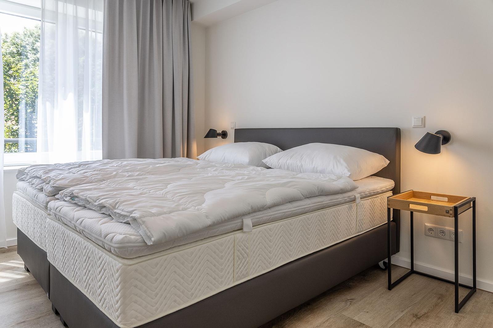Schlafzimmer mit Doppelbett, Fenster und Nachttisch