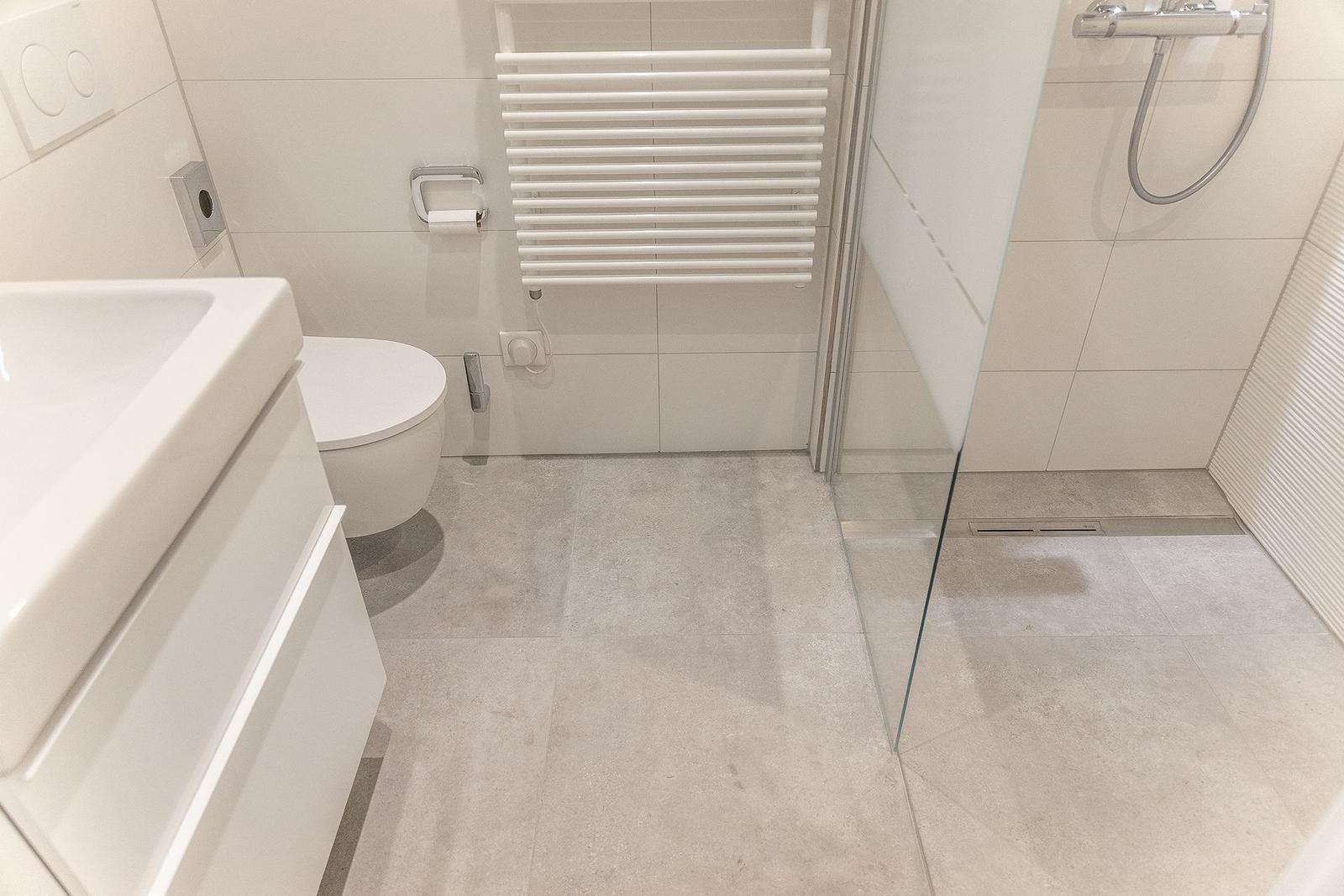 Badezimmer mit Dusche, Toilette und Waschbecken.