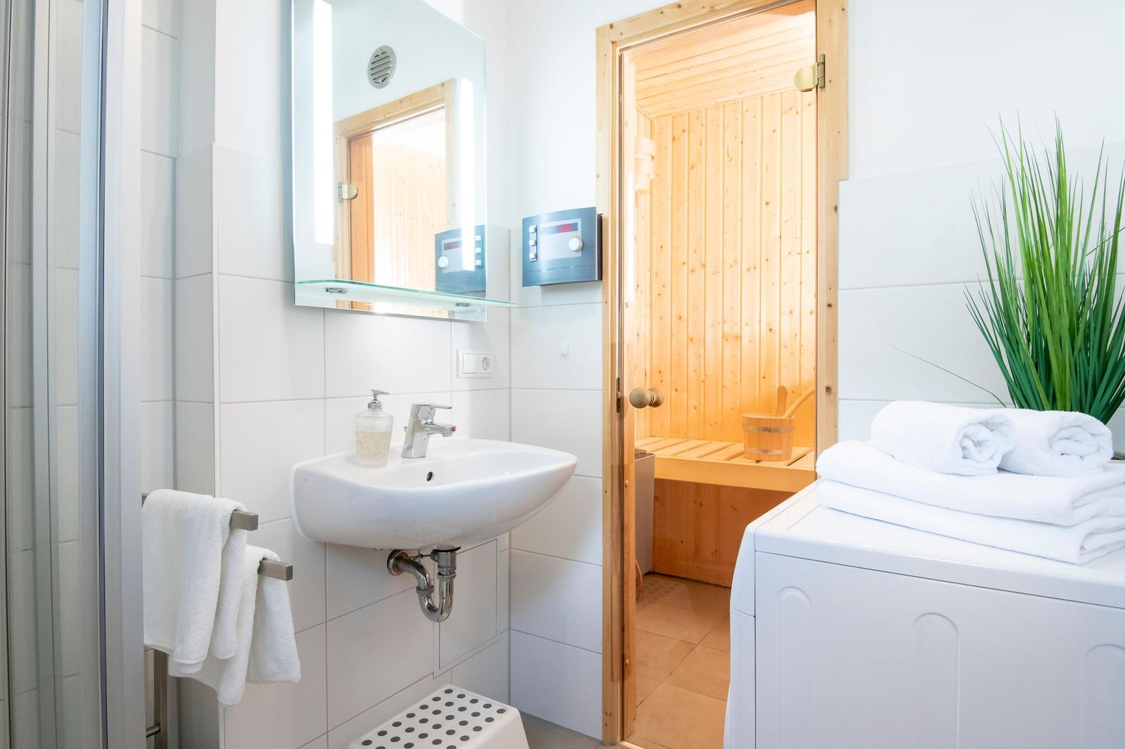 Badezimmer mit Sauna, Waschbecken und Toilettenbereich.