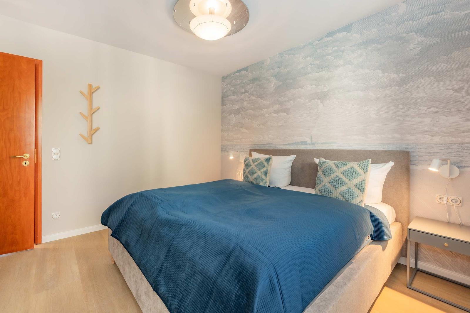 Schlafzimmer mit Bett, Wandtapete und Nachttisch