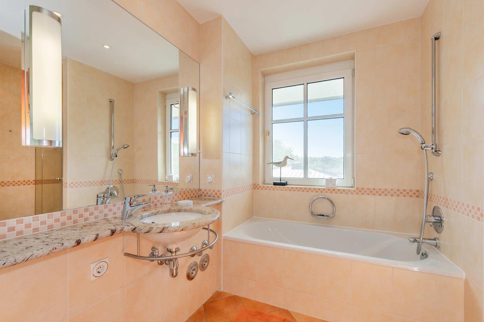 Bad mit Badewanne, Waschbecken und Fenster mit Blick.
