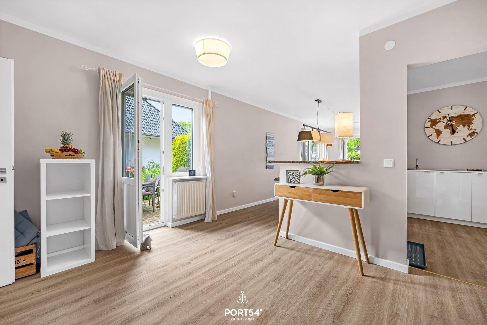 Helle Wohnung mit Holzboden, Fenster zum Garten und modernem Schreibtisch.