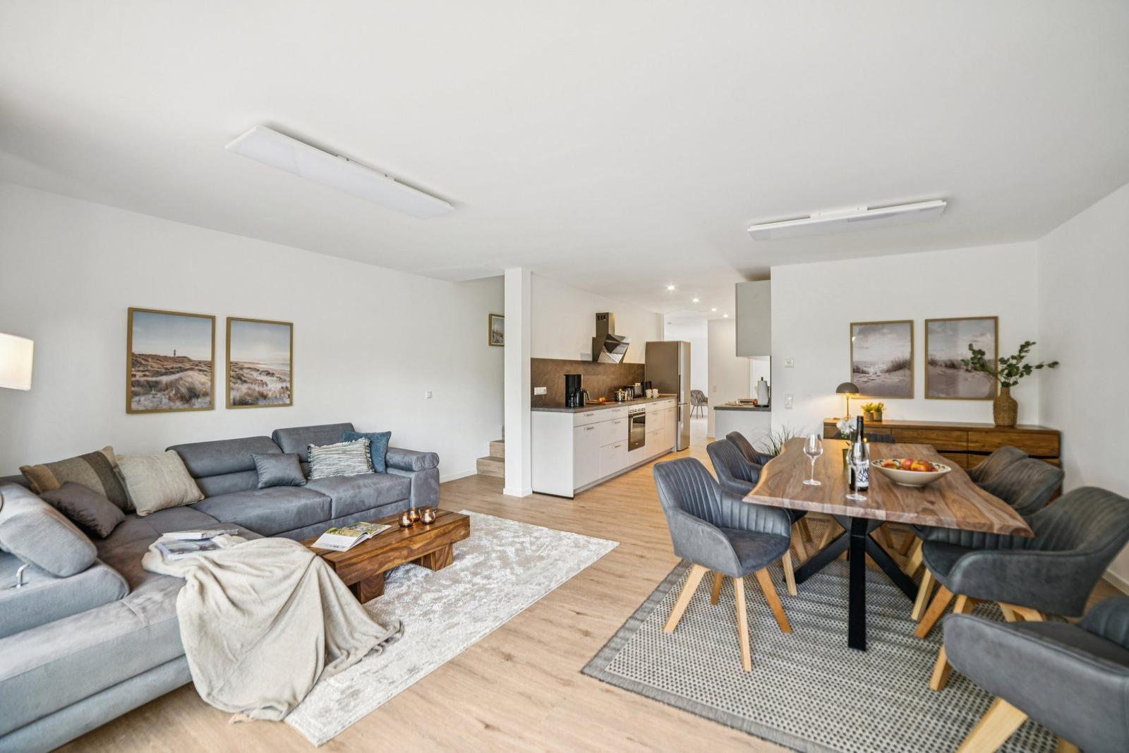 Wohn- und Essbereich mit Sofa, Esstisch und Küchenbereich.
