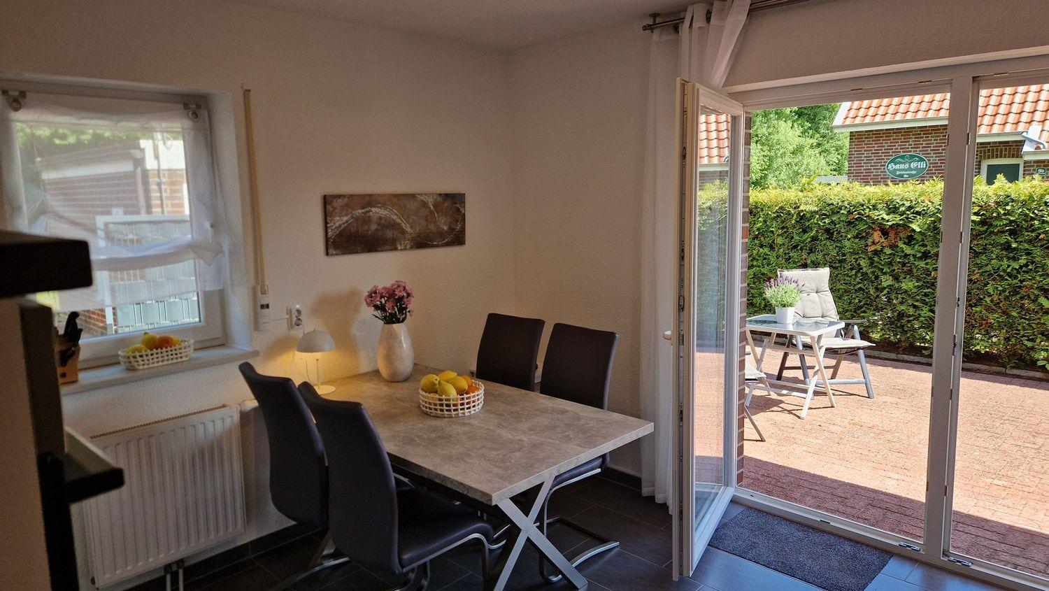 Esszimmer mit Tisch, Stühlen und Blick auf den Garten.