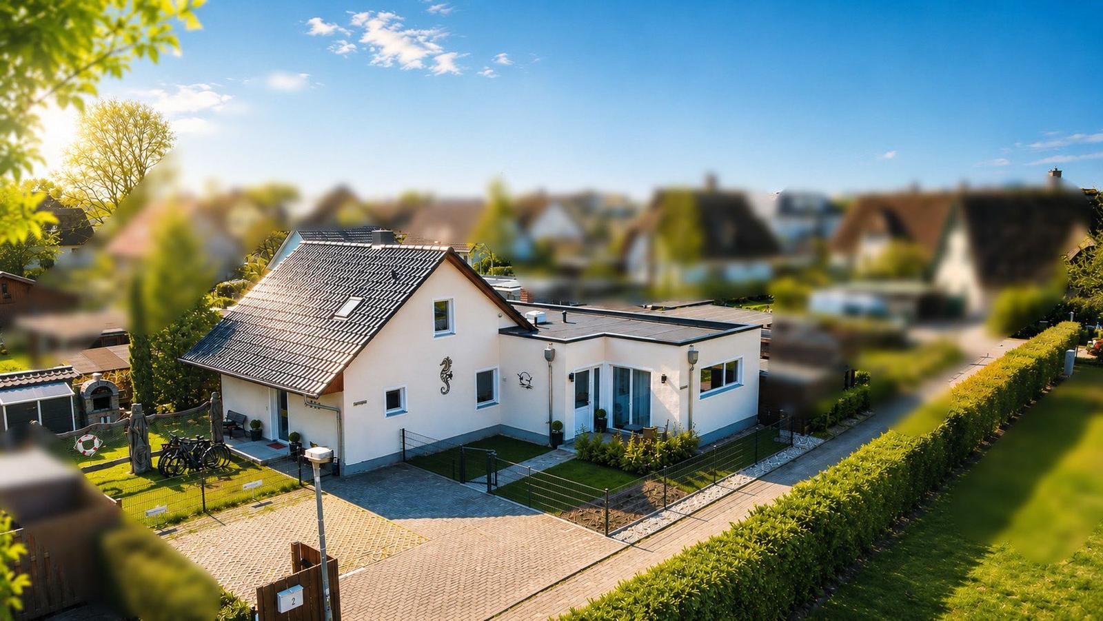 Modernes Haus mit Garten, Terrasse und Fahrrädern. Blick auf die Umgebung.