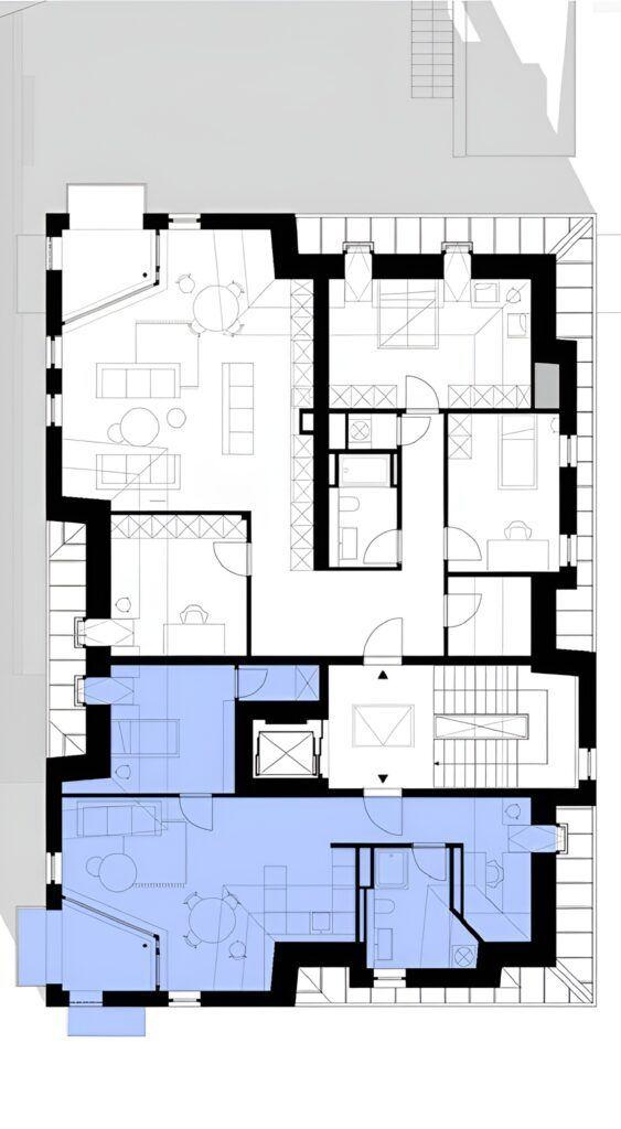 Architekturzeichnung einer Wohnung mit markierten Räumen und Treppenhaus.