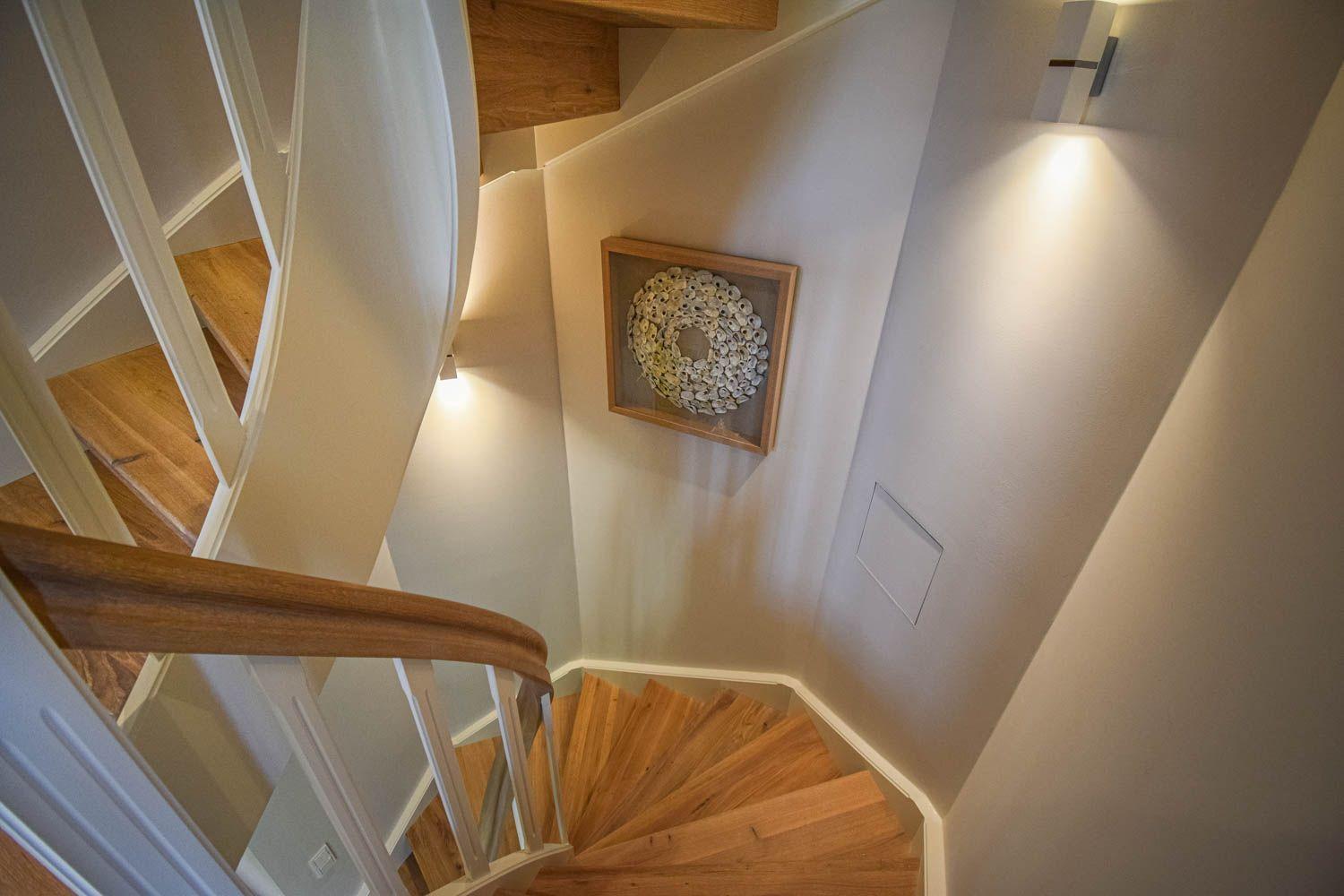 Hölzerner Wendeltreppe mit weißer Balustrade und Wandbild