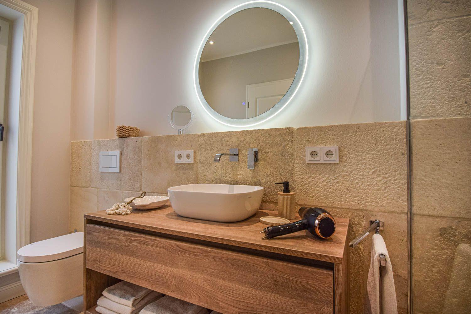 Badezimmer mit Waschbecken, Spiegel und Toilette