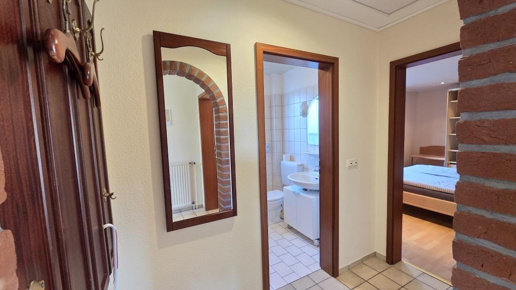 Flur mit Spiegel, Badezimmer und Schlafzimmer sichtbar