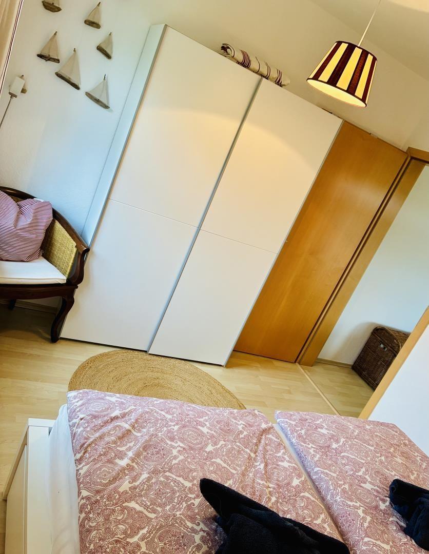 Schlafzimmer mit Bett, Kleiderschrank und Sessel
