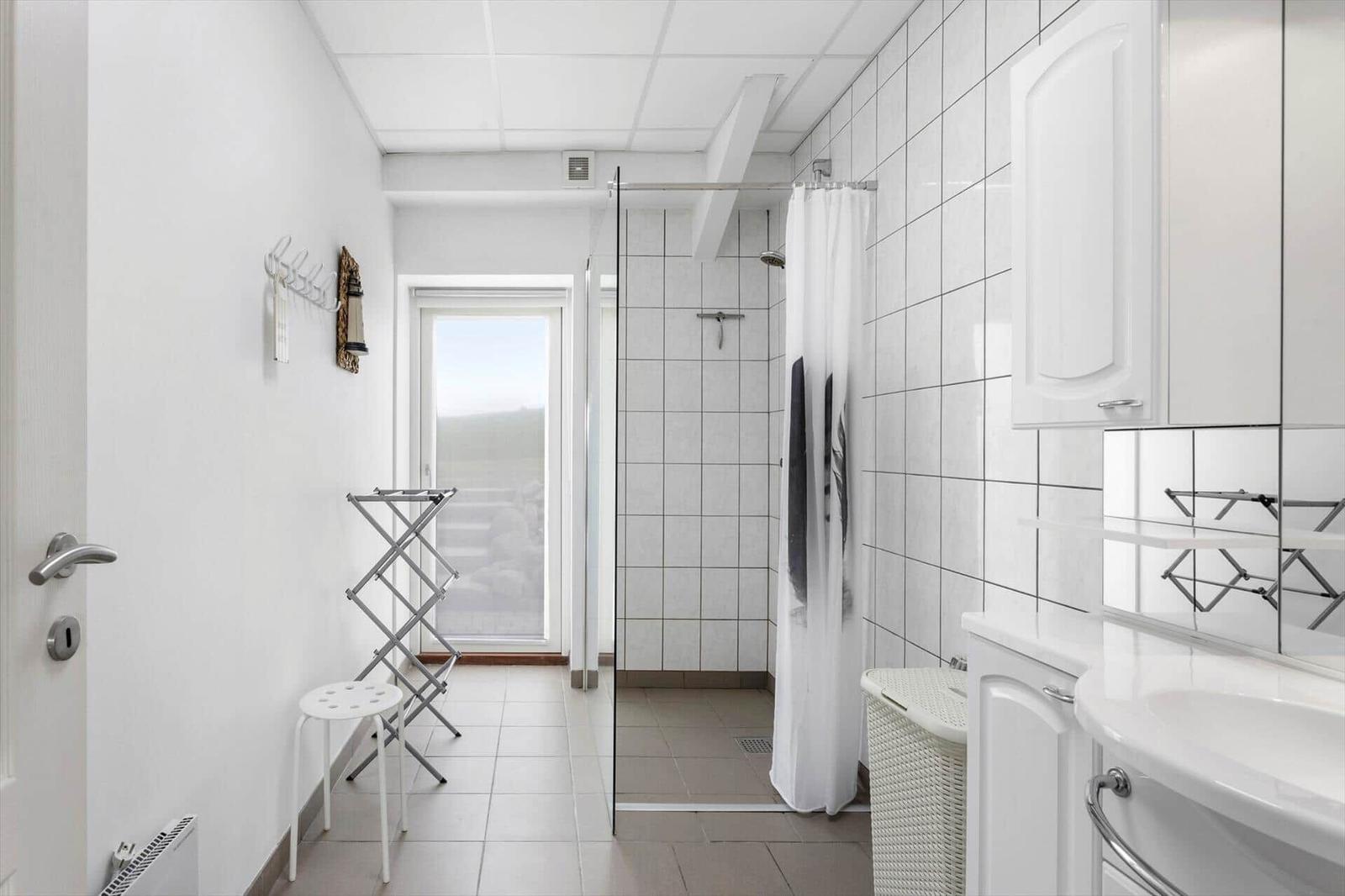 Bathroom with shower, sink, and window
