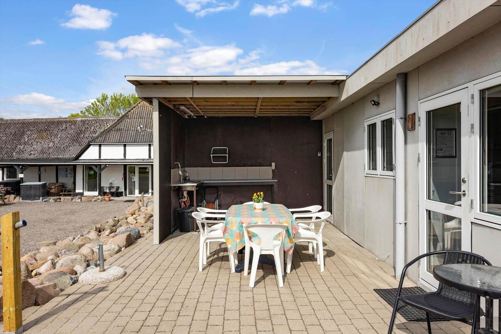Terrace with table, chairs, and grill area at modern building