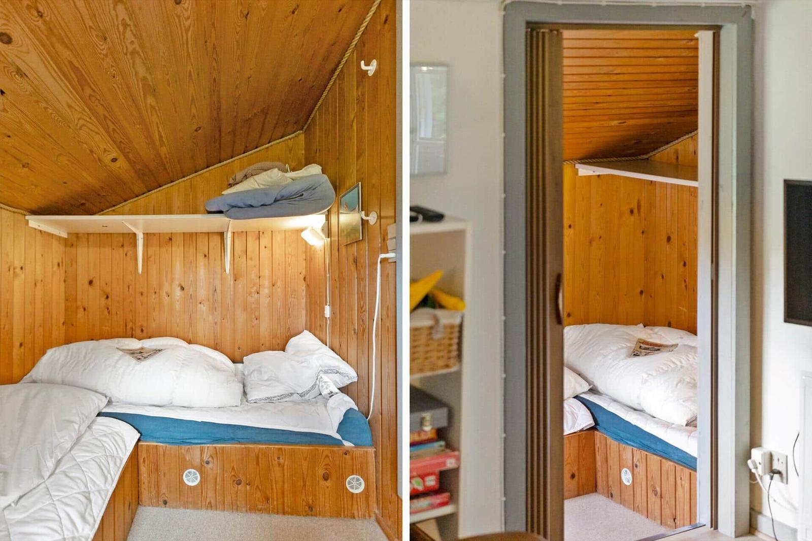 Bedroom with wooden walls and ceiling, bed with white pillows and blue mattress.