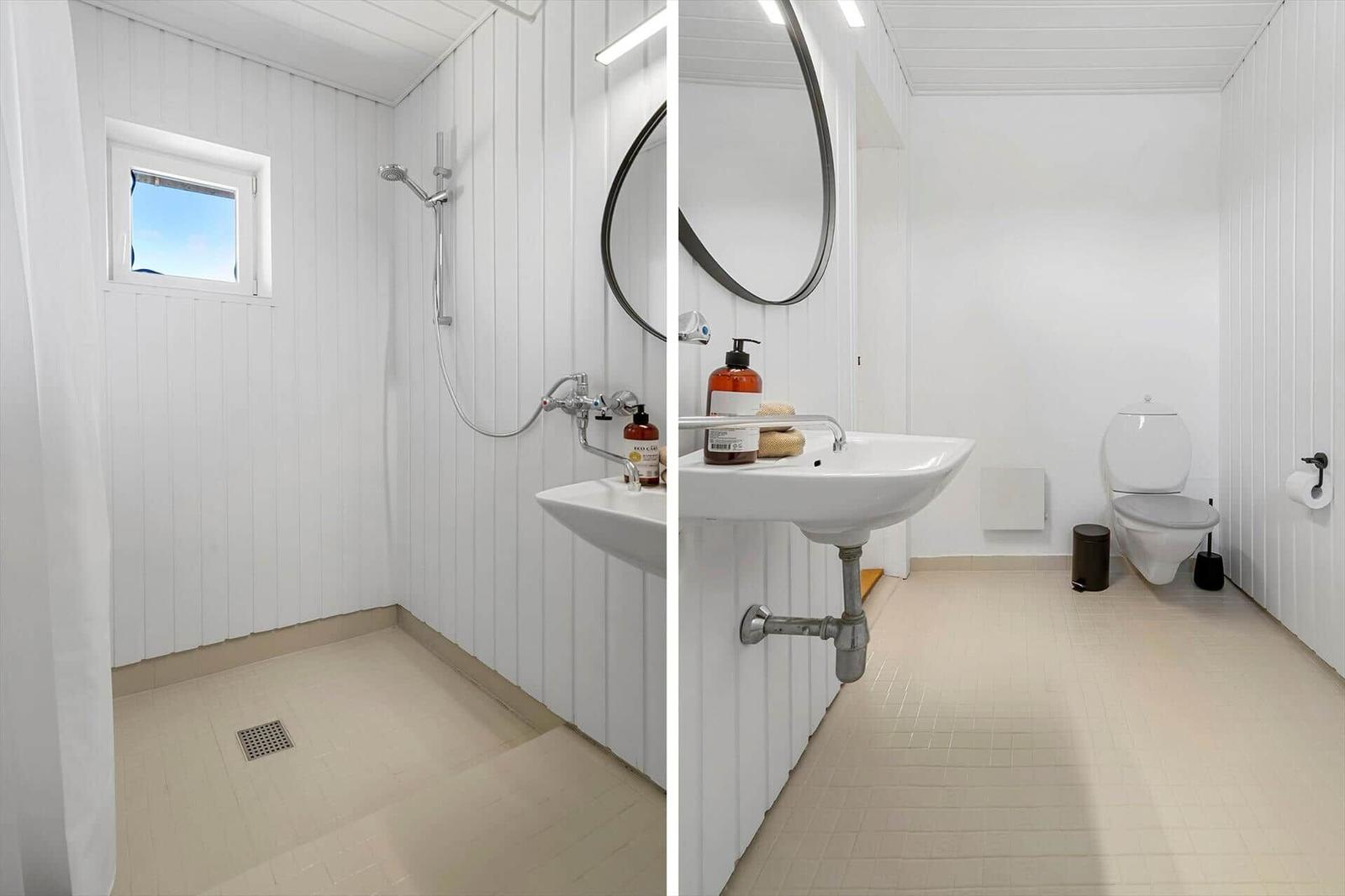 Bathroom with shower, sink, and toilet. White walls and floor tiles.