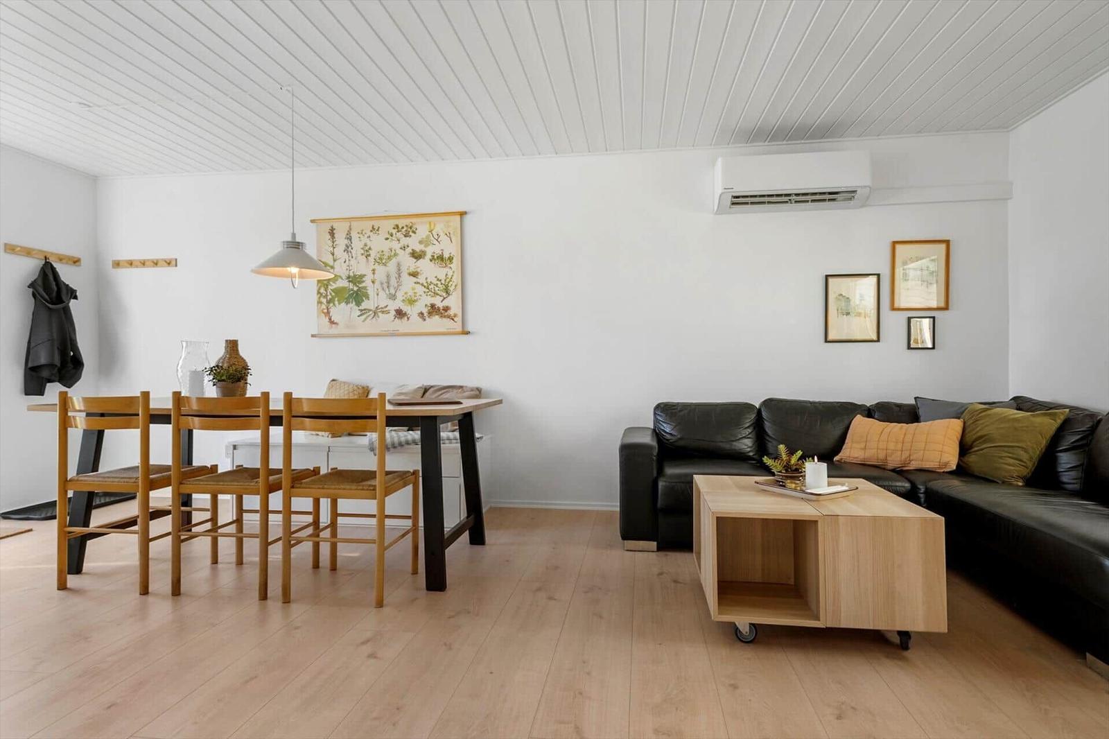 Living and dining area with sofa, table, chairs, and wall art.