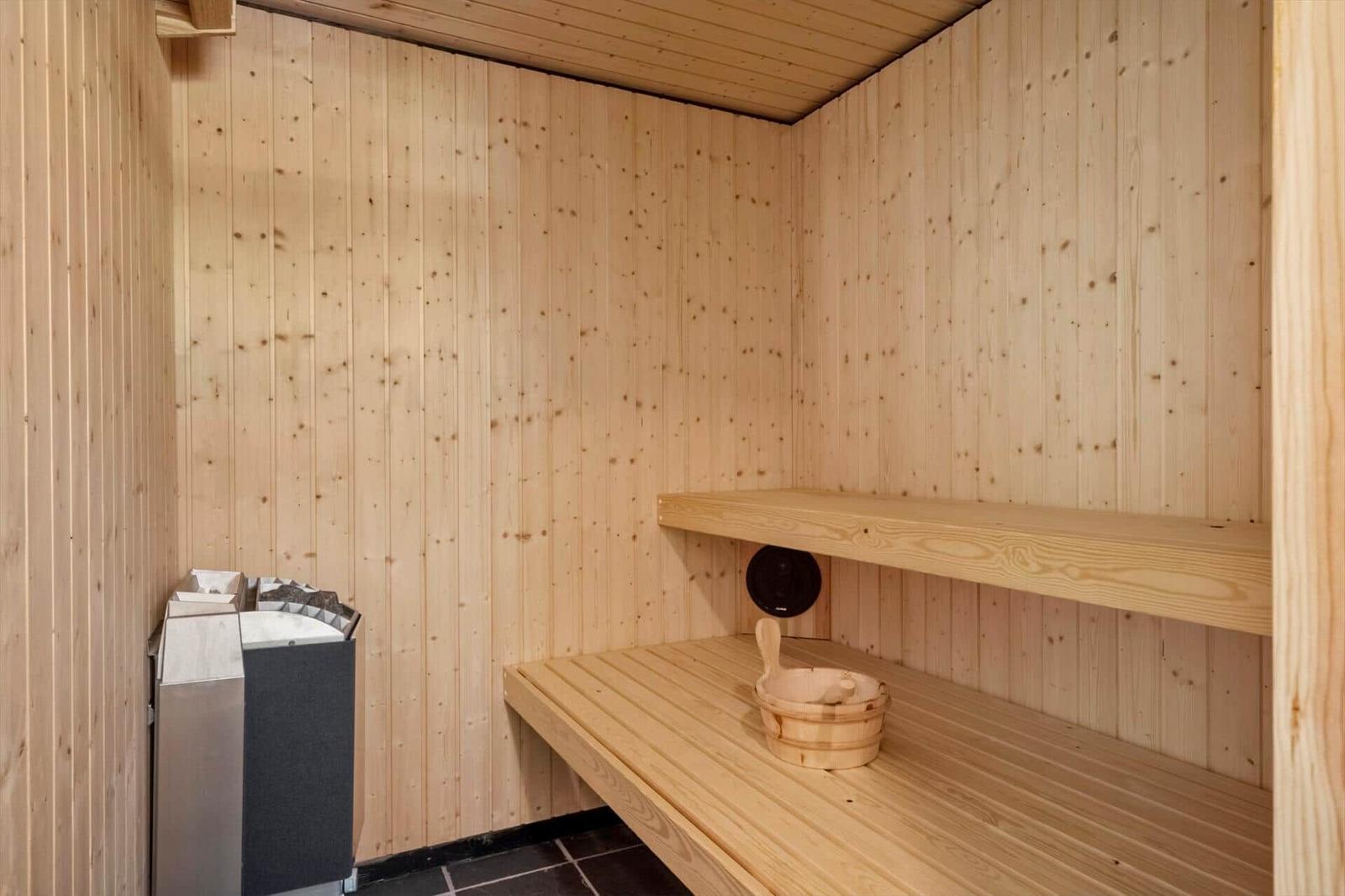 Sauna mit Holzwand, Bank und Holzwanne mit Löffel