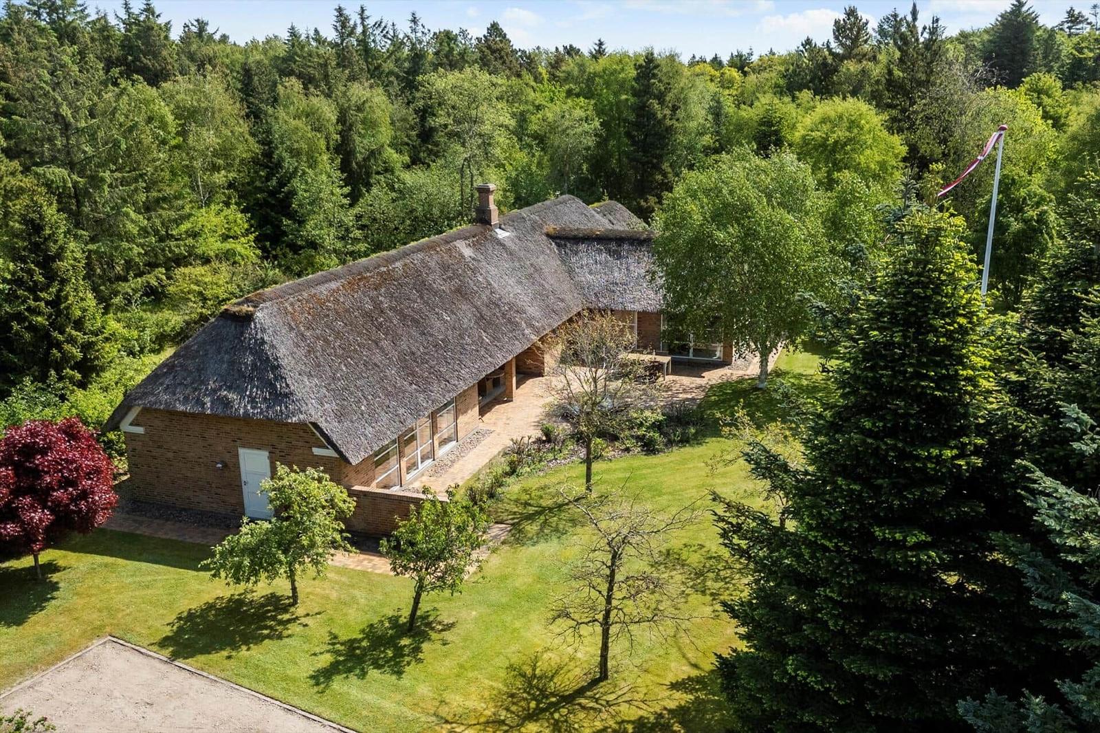 Haus mit Strohdach und Garten in grüner Umgebung