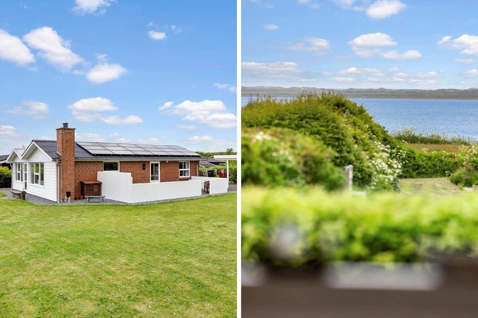 Haus mit Solaranlage und Garten. Blick auf Wasser und Hügel.