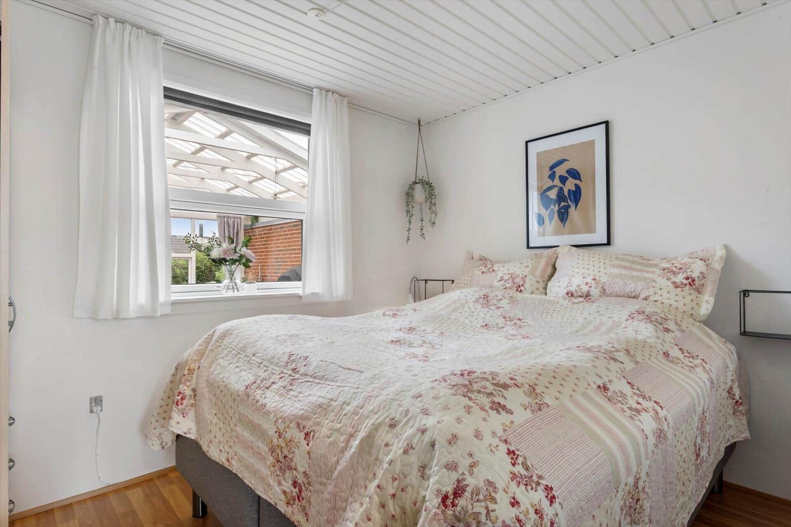 Schlafzimmer mit Bett, Fenster und Wandbild