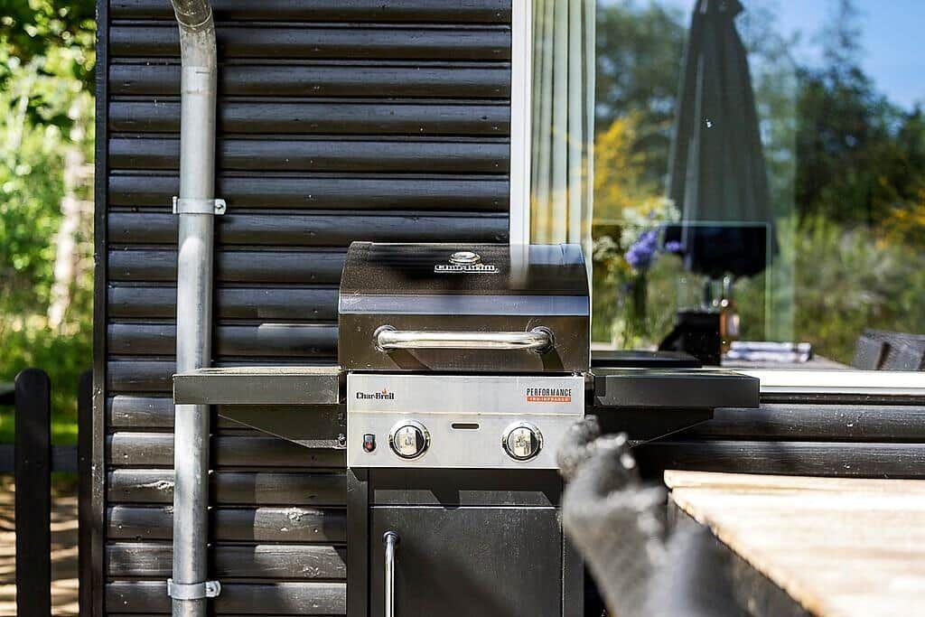 Char-grill on terrace next to wooden wall and table