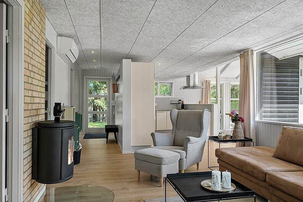 Living area with seating, wood stove, and view of garden.