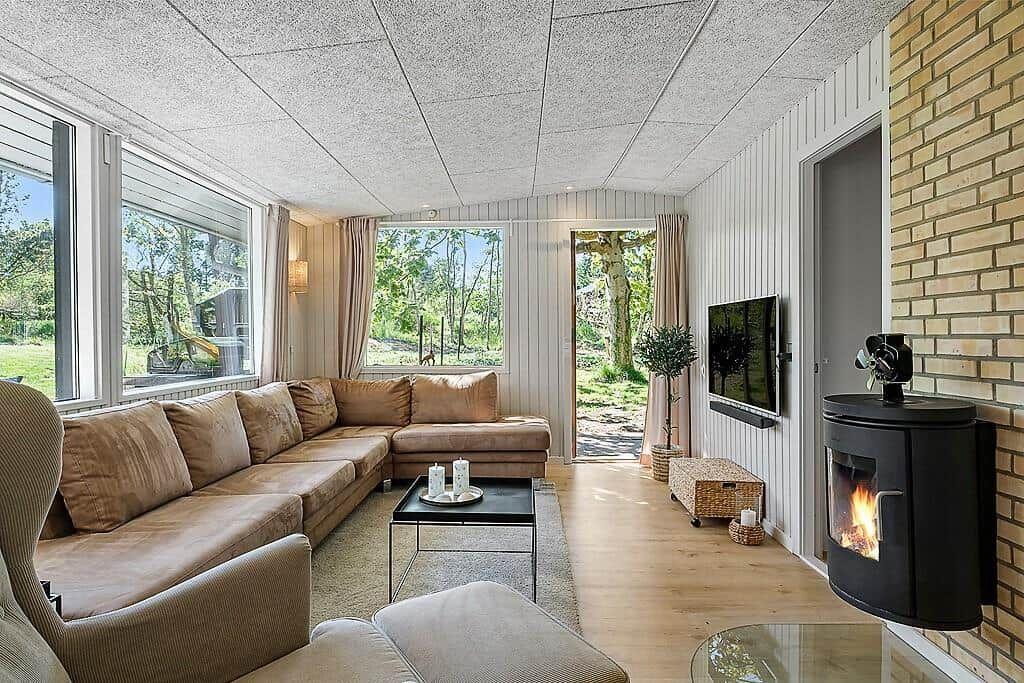 Living room with sofa, fireplace, and windows to the garden.