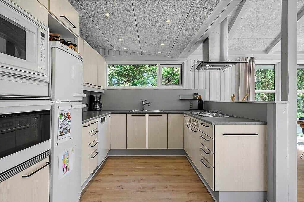 Kitchen with light cabinets, countertop, and windows to the garden.