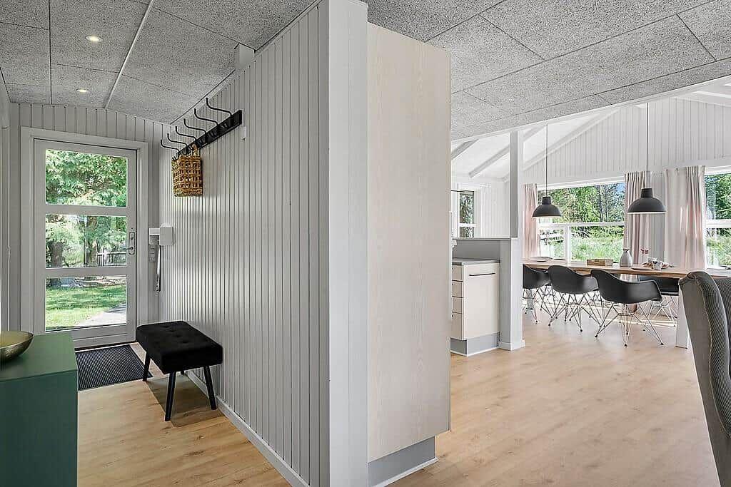 Entrance area with coat rack and view into dining area with table and chairs.