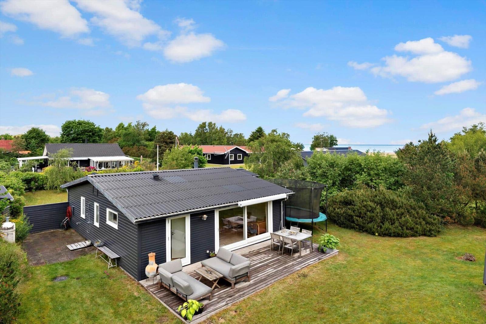 A house with terrace, garden, and trampoline. View of the sea.