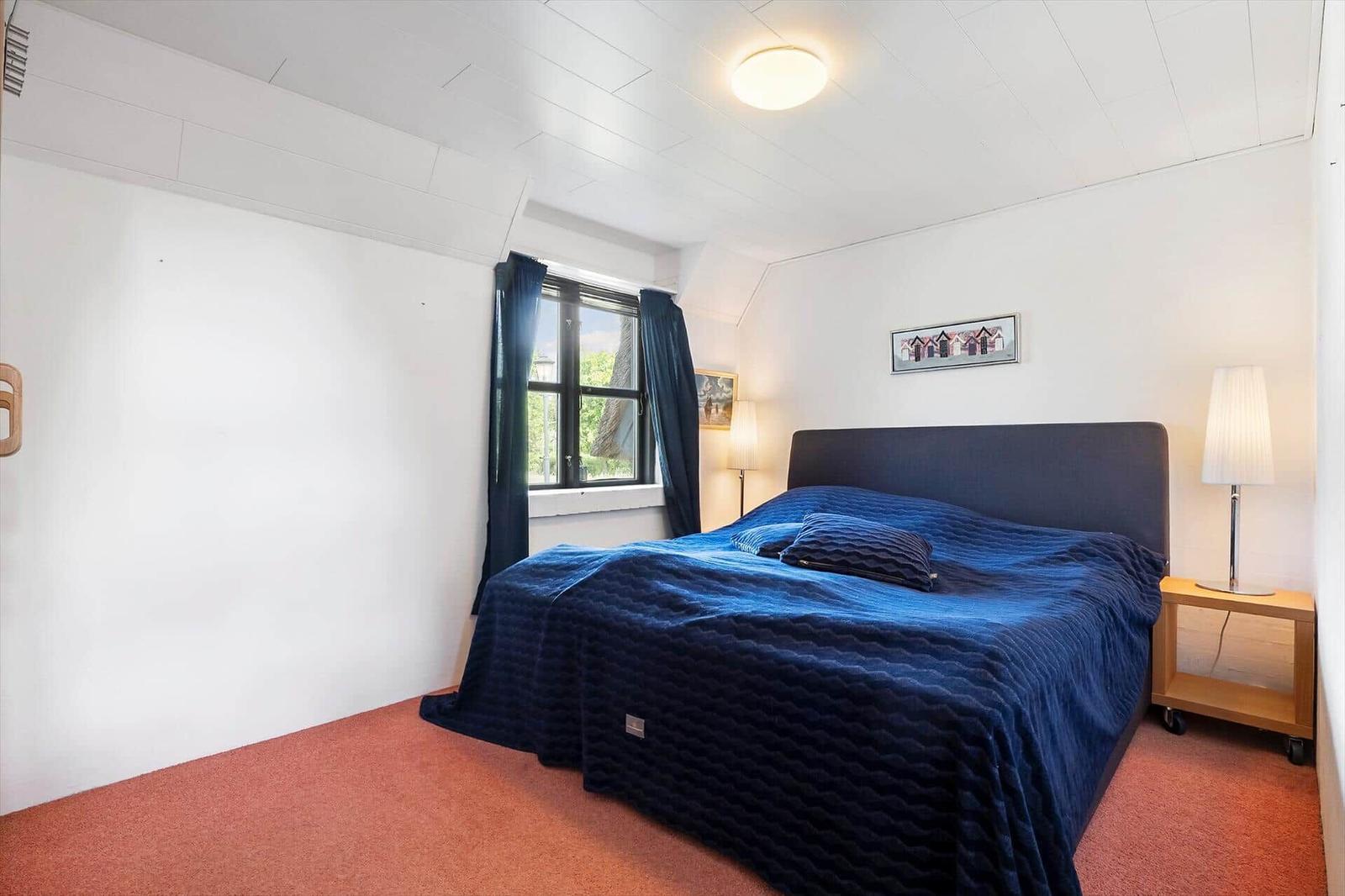 Schlafzimmer mit Bett, Fenster und Nachttisch