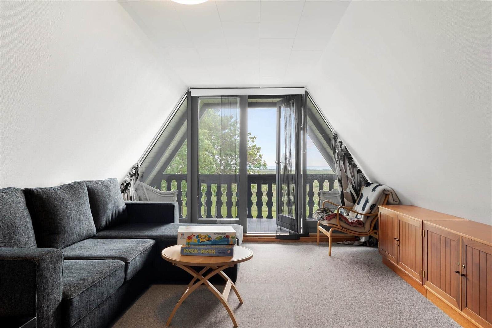 Wohnzimmer mit Sofa, Couchtisch und Blick auf Balkon.