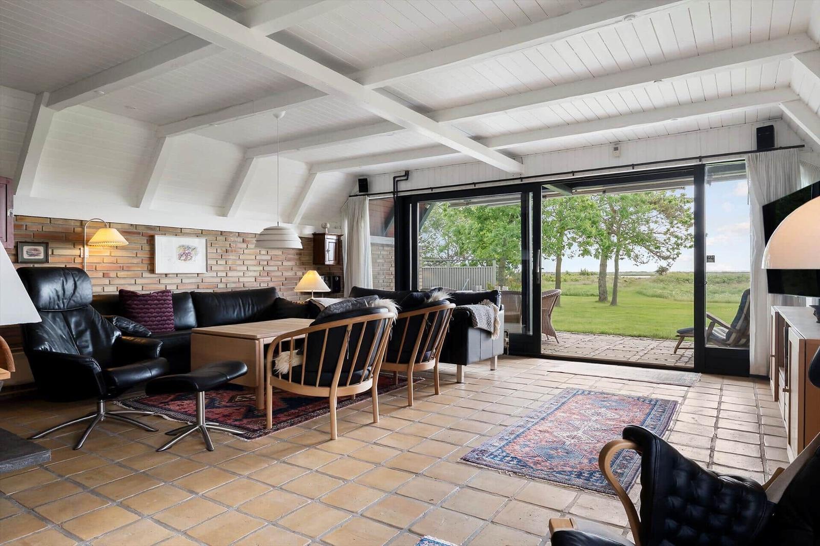 Wohnzimmer mit Sitzgelegenheiten, Flur und Blick auf Garten
