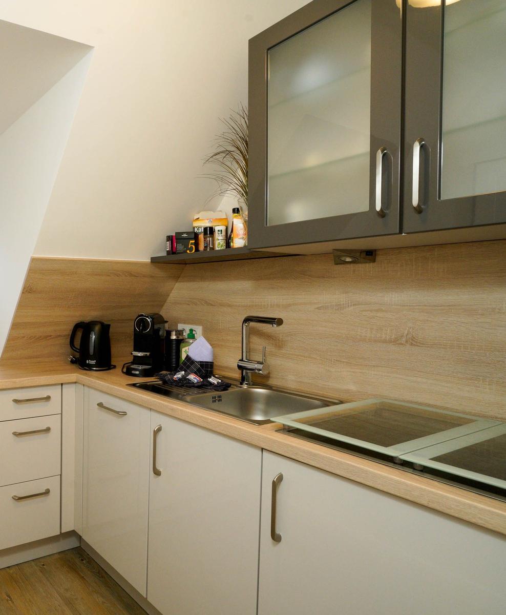 Küche mit Schrank, Spüle, Kochfeld und Kaffeemaschine