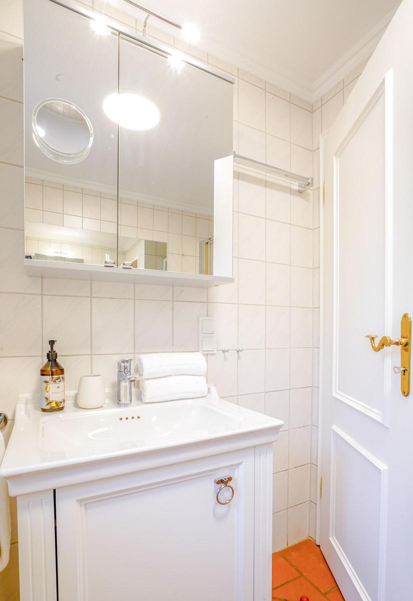 Badezimmer mit Waschbecken, Spiegel und Handtuch
